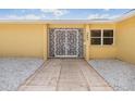 Elegant white decorative security door with stone path, white rock landscaping, and yellow exterior at 1421 Sea Gull S Dr, St Petersburg, FL 33707