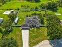Aerial view of the property with a screened-in pool, a large yard, and a long driveway at 1521 Avondale Ridge Dr, Plant City, FL 33567