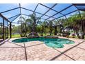 Beautiful, screened-in pool with waterfall feature and lush tropical landscaping at 1521 Avondale Ridge Dr, Plant City, FL 33567
