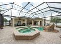 Backyard screened-in pool with spa and outdoor seating on a brick patio, ideal for entertaining at 1521 Avondale Ridge Dr, Plant City, FL 33567