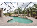 Inviting screened-in pool area featuring a spa and rock waterfall, perfect for relaxation and entertainment at 1521 Avondale Ridge Dr, Plant City, FL 33567