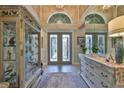 Spacious foyer featuring double doors, transom windows, tile flooring, and elegant furnishings at 15303 Valencia Del Sol St, Wimauma, FL 33598