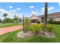 Lovely single-story home with a manicured lawn and garden beds, featuring a vibrant red driveway at 2015 W Del Webb Blvd, Sun City Center, FL 33573
