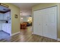 Hallway with light wood floors and closet with access to kitchen, dining and living areas at 2913 Fig Ct, Palm Harbor, FL 34684