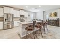 Bright, open kitchen with white cabinets, stainless steel appliances, and a granite island with bar seating at 32231 Conchshell Sail St, Wesley Chapel, FL 33545