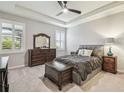 Serene bedroom with tray ceiling, neutral colors, and plantation shutters for a relaxing retreat at 32231 Conchshell Sail St, Wesley Chapel, FL 33545