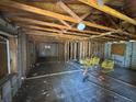 Unfinished interior featuring exposed wood beams, concrete block walls, and debris scattered throughout at 3308 E Frierson Ave, Tampa, FL 33610