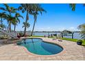 Beautiful kidney-shaped pool and spa with a dock on the water in the background at 443 18Th Ave, Indian Rocks Beach, FL 33785