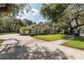 Well-maintained home with mature trees, stone accents, and a circular driveway at 502 Creekside Ct, Safety Harbor, FL 34695