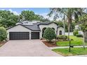 Beautiful single-story house features a brick driveway, a three-car garage, and solar panels at 5109 Hartwell Loop, Land O Lakes, FL 34638