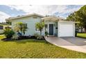 Inviting exterior showcases a light-colored home, neat lawn, and attached garage at 5527 Kelly N Dr, St Petersburg, FL 33703