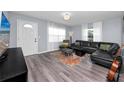 Cozy living room features modern flooring, a leather sectional sofa, and a wall-mounted television at 5717 60Th N Way, St Petersburg, FL 33709