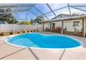 This screened-in pool and patio area features a kidney-shaped pool and an adjacent deck perfect for outdoor living at 5717 60Th N Way, St Petersburg, FL 33709