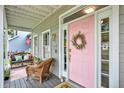 Inviting front door with a pink finish, decorative wreath, and sidelight windows, adding to the home's charm at 5907 S Elkins Ave, Tampa, FL 33611