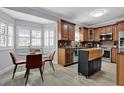 Well-lit kitchen with wood cabinets, stainless steel appliances, a central island, and a cozy breakfast nook at 5907 S Elkins Ave, Tampa, FL 33611