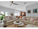 Bright living room featuring neutral sofas, stylish coffee tables, and an open floor plan to the kitchen at 5907 S Elkins Ave, Tampa, FL 33611