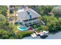 Aerial shot highlighting the backyard oasis with a pool, dock, and boat lift on the water at 6805 Arroyo Dr, New Port Richey, FL 34652