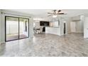 Open-concept living room features tile floors, sliding glass doors to the patio, and views of the kitchen at 1009 Wynnmere Walk Ave, Ruskin, FL 33570