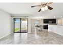Open-concept living room features tile floors, sliding glass doors to the patio, and views of the kitchen at 1009 Wynnmere Walk Ave, Ruskin, FL 33570