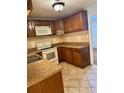 Well-maintained kitchen with brown cabinets, white appliances, and tile flooring at 1020 85Th N Ave # 223, St Petersburg, FL 33702