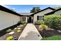 Landscaped walkway leads to the home's entry, showcasing manicured bushes, stone accents and freshly laid mulch at 10412 Tara Dr, Riverview, FL 33578