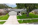 Beautiful single-story home featuring a two-car garage, mature landscaping and large shade tree at 10412 Tara Dr, Riverview, FL 33578