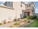 Charming home entrance with a red door, landscaped walkway, and stone garden bed at 10424 Laguna Plains Dr, Riverview, FL 33578