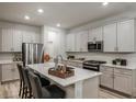 Bright kitchen with white cabinetry, stainless steel appliances, and an island with a breakfast bar at 12172 Cattleside Dr, Riverview, FL 33579