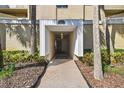 Covered entrance to condo building #13618 is framed by palm trees, with visible interior lighting at 13618 Greenfield Dr # 105, Tampa, FL 33618