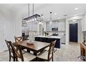 Bright kitchen with dining area, showcasing pendant lighting, island with bar seating, and stainless steel appliances at 14110 Damselfly Dr, Tampa, FL 33625
