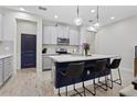Modern kitchen features an island with bar seating, white countertops, and stainless steel appliances at 14110 Damselfly Dr, Tampa, FL 33625