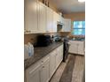 Efficient kitchen with white cabinets, dark countertops, and modern appliances for everyday cooking at 1806 Marvy Ave, Tampa, FL 33612