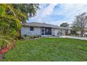 Inviting single-Gathering home featuring manicured lawn, lush landscaping, and a screened-in porch area at 2620 49Th N Ave, St Petersburg, FL 33714