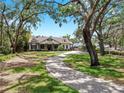 Elegant home with a brick-paved driveway and lush greenery at 2621 Stearns Rd, Valrico, FL 33596
