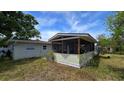 Back exterior featuring a spacious screened-in porch, ideal for relaxing and enjoying the outdoors at 3925 W Eden Roc Cir, Tampa, FL 33634