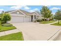 Inviting one-story home with a spacious three-car garage and a beautifully landscaped front yard, showcasing curb appeal at 4166 Epic Cv, Land O Lakes, FL 34638