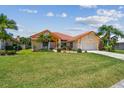 Charming single-Gathering home featuring a well-manicured lawn, beautiful landscaping, and a terracotta-tiled roof at 5001 Queen Palm Ne Ter, St Petersburg, FL 33703