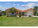 Charming single-Gathering home featuring a well-manicured lawn, beautiful landscaping, and a terracotta-tiled roof at 5001 Queen Palm Ne Ter, St Petersburg, FL 33703