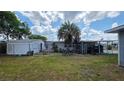 Spacious backyard partially enclosed by a chain-link fence, with a storage shed and mature palm tree at 5647 Arrowhead Dr, Zephyrhills, FL 33542