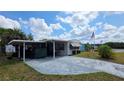 Single-story home with a carport, neatly maintained landscaping, and an American flag displayed at 5647 Arrowhead Dr, Zephyrhills, FL 33542