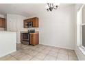 Kitchen and dining area featuring tiled floors, wood cabinets, and stainless steel appliances at 5839 Meadowpark Pl, Lithia, FL 33547