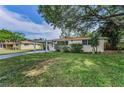 Well-maintained single-story home featuring a covered carport and a large, shady tree at 629 Lexington St, Dunedin, FL 34698