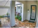 Charming brick courtyard with a welcoming 'Welcome' sign, green foliage, and metal table and chairs, perfect for relaxation at 6820 Muncaster Ct, Tampa, FL 33625