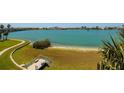 A picturesque backyard featuring manicured lawn, sandy beach, and serene waterfront views at 7872 Sailboat Key S Blvd # 301, South Pasadena, FL 33707