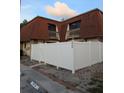 Townhouse with a white fence, red brick walk way and dark windows at 8114 Oak Trace Way # D, Tampa, FL 33634