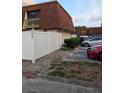 Townhouse with a white fence, red brick walk way, dark windows and parking at 8114 Oak Trace Way # D, Tampa, FL 33634