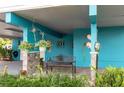 Cozy, covered outdoor space with an iron bench, hanging plants, and decorative accents at 854 77Th N Ave, St Petersburg, FL 33702