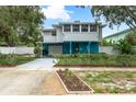 Charming two-story home with a blue foundation, carport, manicured front lawn and privacy fence at 854 77Th N Ave, St Petersburg, FL 33702
