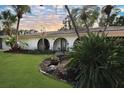 Inviting home with a well-maintained lawn, tropical plants and arched entryway at 8740 15Th N St, St Petersburg, FL 33702