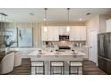 Bright kitchen features a central island with bar stool seating, stainless appliances, and hanging pendant lights at 9997 Surrey Rose Dr, San Antonio, FL 33576